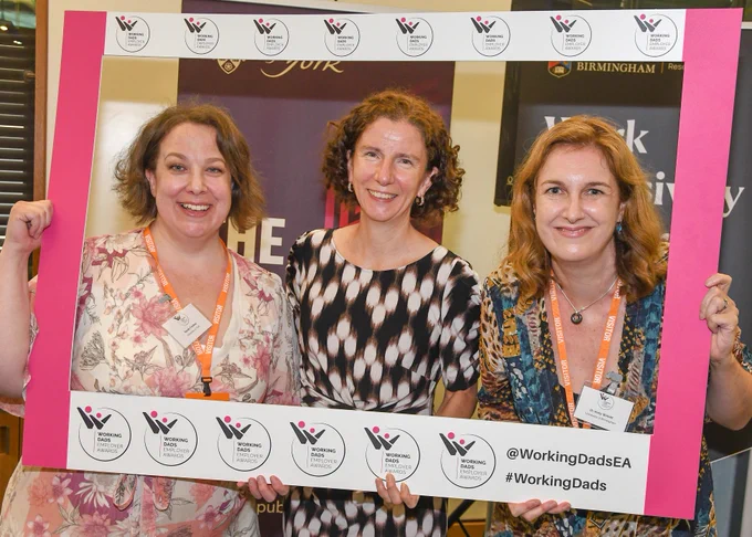 A photograph of Dr Sarah Forbes, Rt Hon Anneliese Dodds MP and Dr Holly Birkett. They are standing with a cut-out border with the Working Dads Employer Awards logo around it.