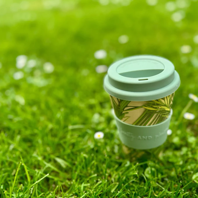 Reusable coffee cup sitting in grass