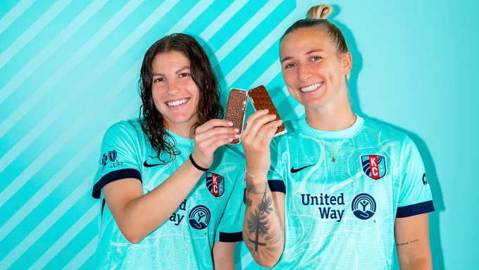 Players Hailie Mace and Izzy Rodriguez smiling holding ice cream sandwiches. 