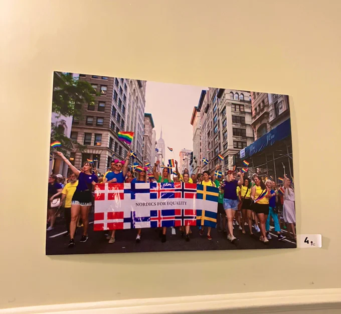 Image of photograph displayed in City Hall of Nordics for Equality at NYC Pride with a colorful banner marching in the street. 