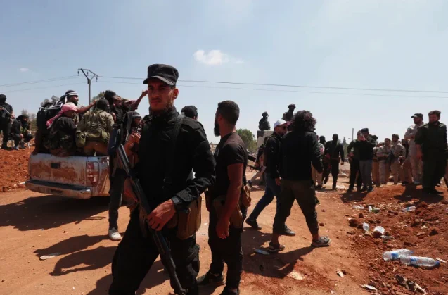 Syrian government security forces block Bedouin fighters, background, from entering Sweida province, in Busra al-Harir village, southern Syria on Sunday.

Omar Sanadiki/AP