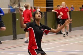 Secondary pupil on sports court playing badminton