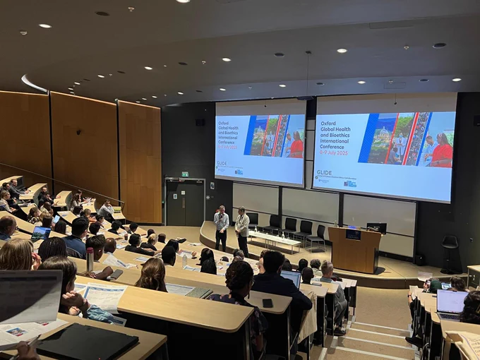 Photo of a lecture theatre with slides in the front