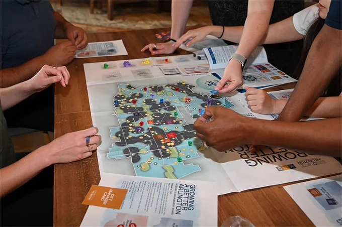 Several people playing a board game, strategizing over a map filled with tokens and cards.