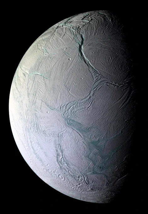 A masterpiece of deep time and wrenching gravity, the tortured surface of Saturn's moon Enceladus and its fascinating ongoing geologic activity tell the story of the ancient and present struggles of one tiny world. Long cracks tear across the white, icy surface revealing ridges that look a light blue. Observations made by the Cassini spacecraft show that this small moon of Saturn has an ice-covered water ocean that erupts into space, forming plumes of material. 