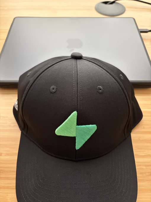Hat with supabase logo in front of a MacBook