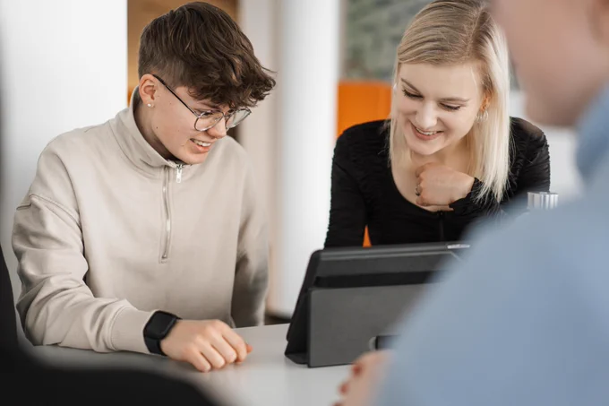 Ein Mann und eine Frau schauen gemeinsam in ein Tablet.