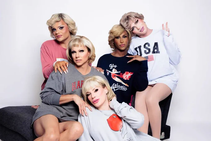 A portrait of five drag queens wearing various sweaters