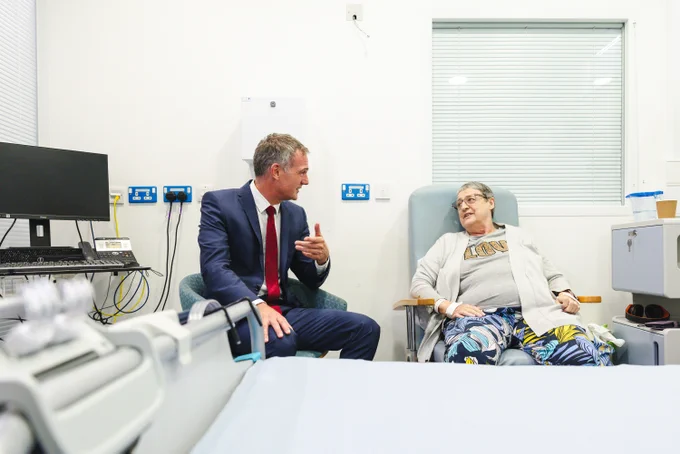 Peter Kyle talking to a patient who has recovered from surgery