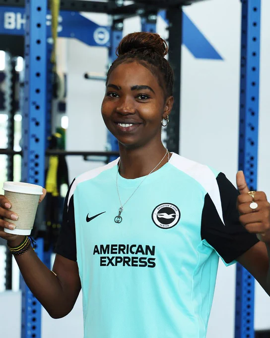 Aisha Masaka smiles with her thumbs up to camera. 