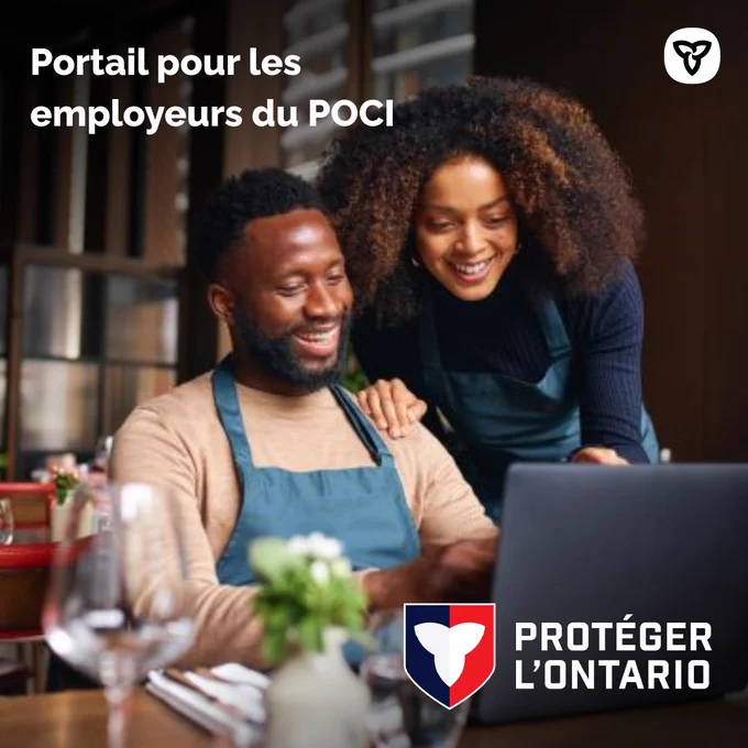 Deux travailleurs penchés sur un ordinateur portable