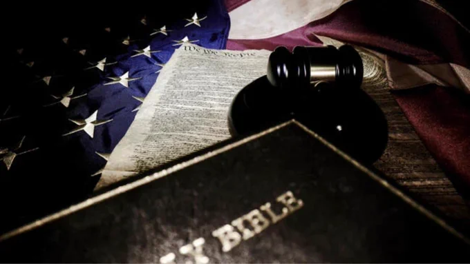 A Bible, judge's gavel and copy of the U.S. Constitution lie atop an American flag.