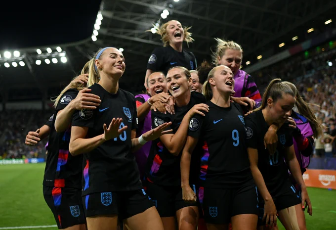 Chloe Kelly of England celebrates with her teammates after scoring her team's second goal from a rebound following a saved penalty in extra-time