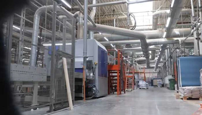 "Interior view of an industrial tissue and converting facility showing large-scale dust extraction systems, ductwork, and machinery aimed at improving air quality and energy efficiency.