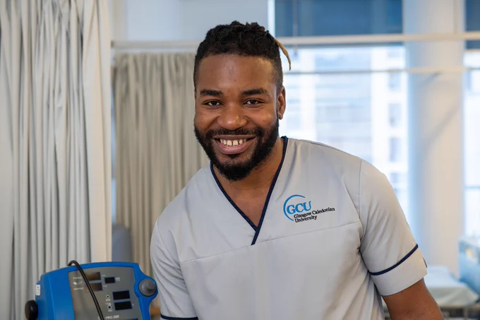 Nursing student smiling at the camera in GCU's Simulation Centre.