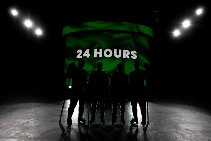 Four black silhouettes standing in front of the REA videoboard with "24 hours" on it to tease the release of new uniforms 