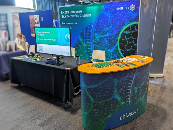 A photograph of an EMBL-EBI booth at a conference.