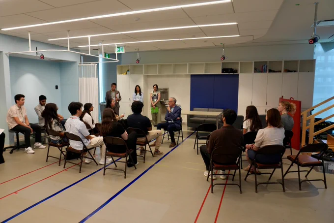 MP Rob Oliphant seated, engaged in discussion with students in Holland Bloorview’s High Performance Hub.