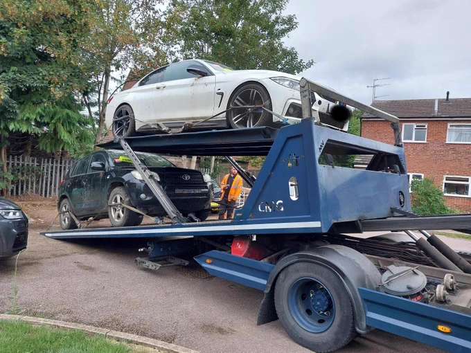This image shows two vehicles on the back of a recovery truck.