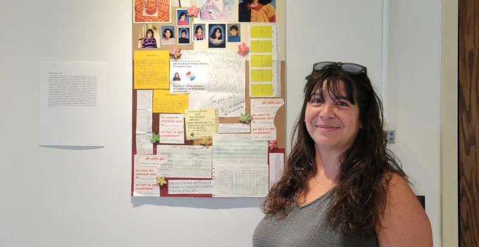 Smiling female professor standing in front of a collage