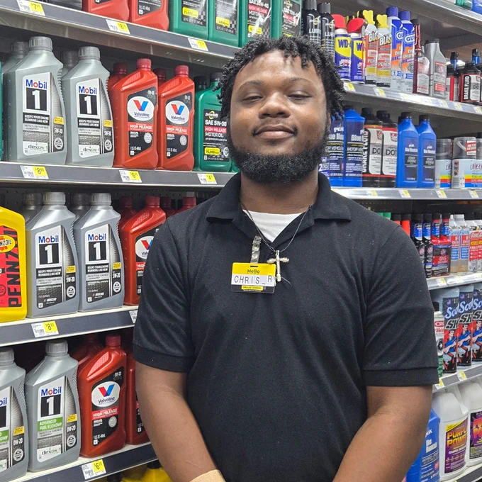 Employee smiling in store aisle. 