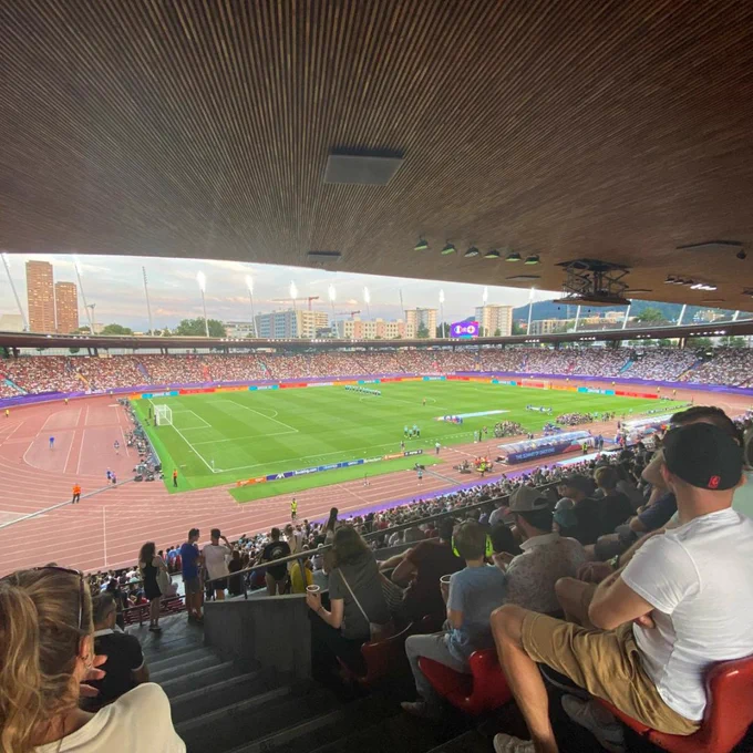 A view of the stadium inside ahead of the Women's EURO 2025 match between England and France. The stands are full and players can be seen entering the pitch. 