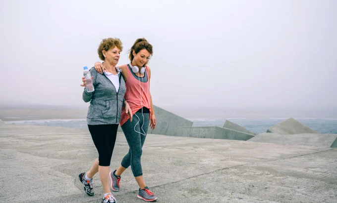 A mother and daughter take a walk by the sea