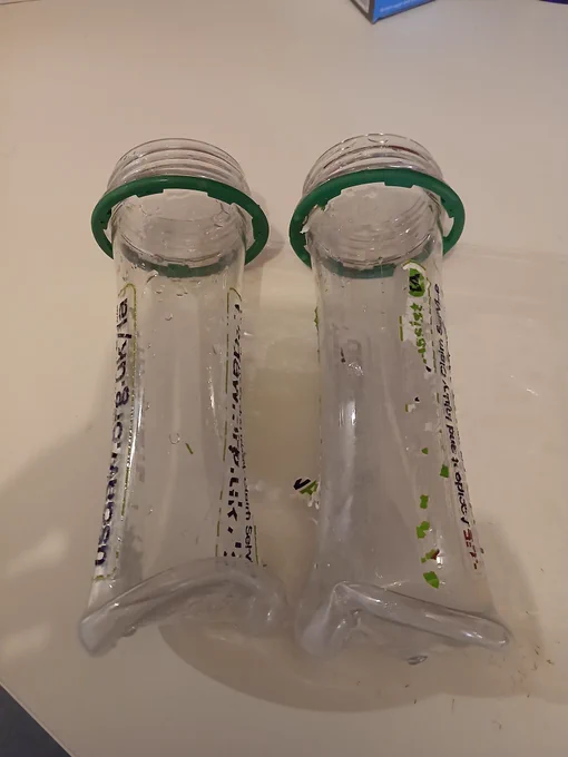 Two plastic bottles that have been shrunk and changed shaped 