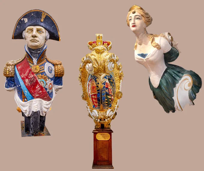 Detailed maritime artifacts including a decorated officer figurehead, a royal crest, and a stylized female figurehead.