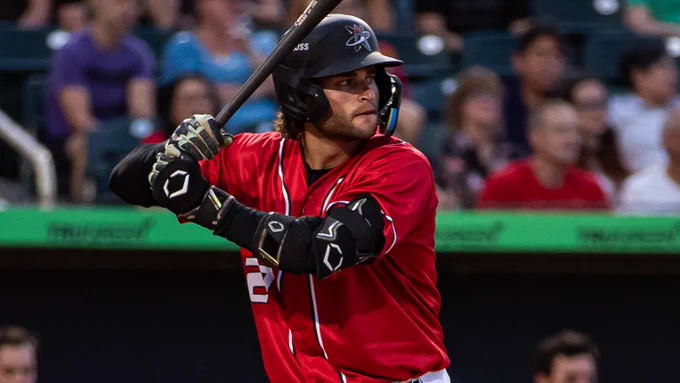 Kyle Karros bats in a red Albuquerque jersey