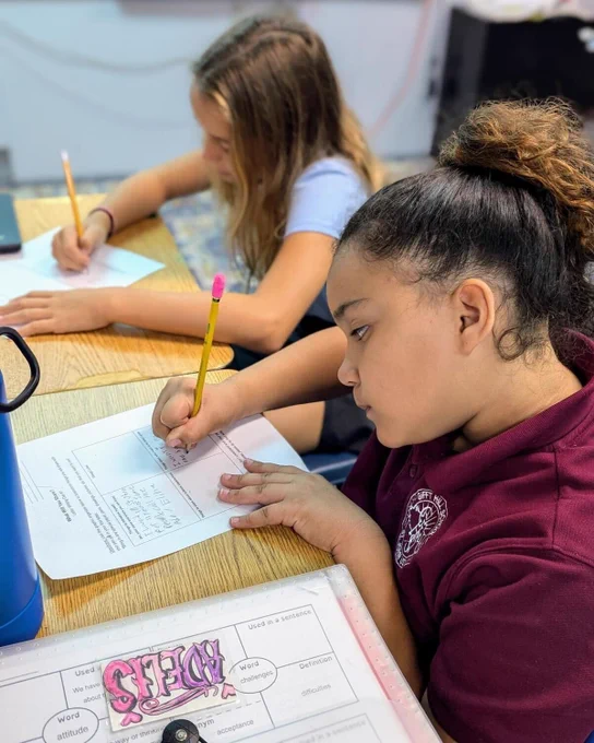 2 students fill out a worksheet from the LPS curriculum