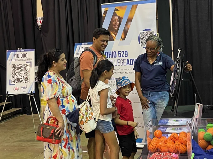 A member of the Ohio Department of Higher Education gives visitors a chance to spin a prize wheel.