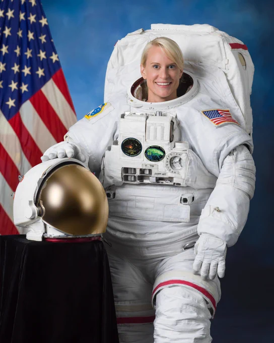 NASA Astronaut Kate Rubins in her spacesuit and in front of an American flag. Credit: NASA