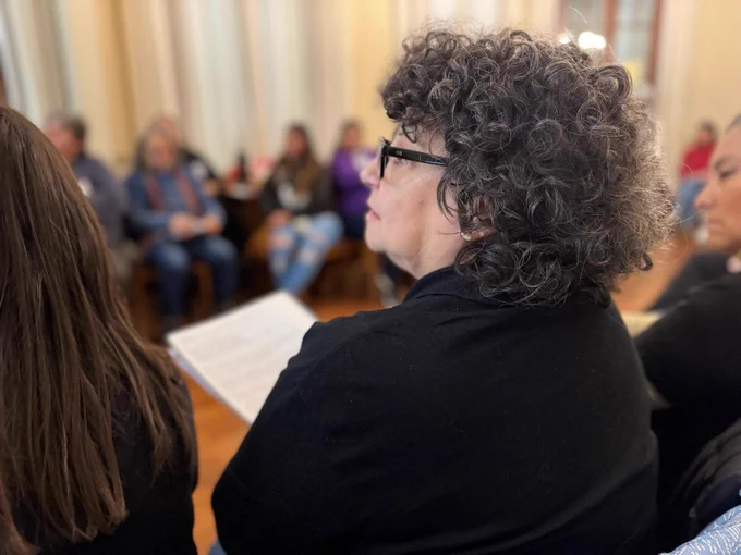 Side profile of a participant at the event with curly hair and glasses.
