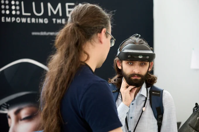 A visually impaired man is wearing .lumen glasses while attentively listening to a .lumen team member explaining how they work. Behind them is a banner with the .lumen logo.​

Text on the post:​
 *"The best technology is designed with everyone in mind.​

That’s why .lumen glasses are designed together with the blind community.​

Every feature, every detail, came from listening to real people, testers, guide dog users, mobility trainers.​

True innovation works for everyone.
