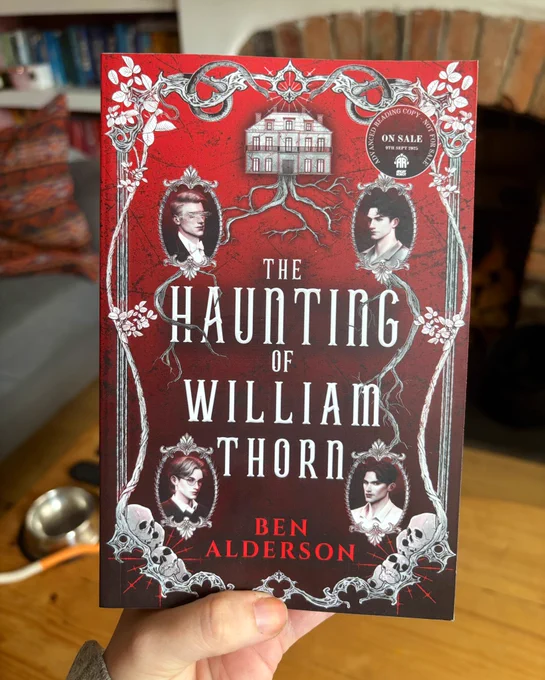 Laura’s hand holding the red covered gothic arc of the novel ‘the haunting of William thorn’ by ben Alderson