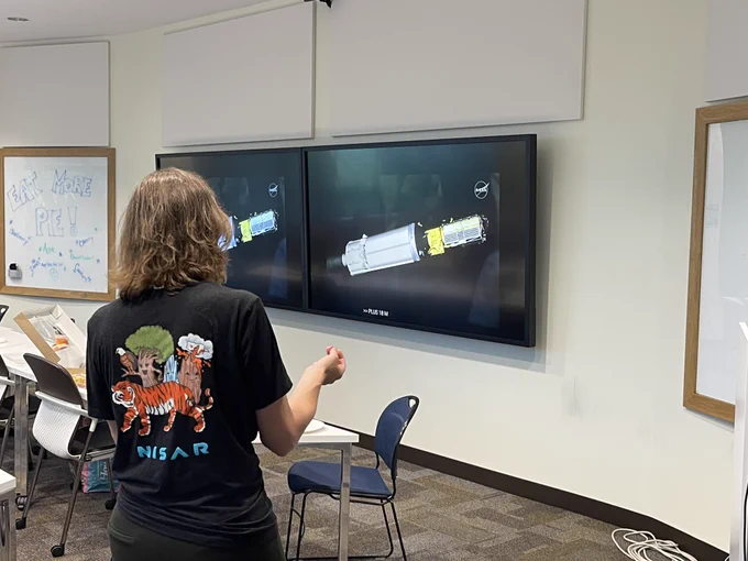 Rowena Lohman watching an animation of the NISAR satellite being put into orbit by a rocket booster launched from India.