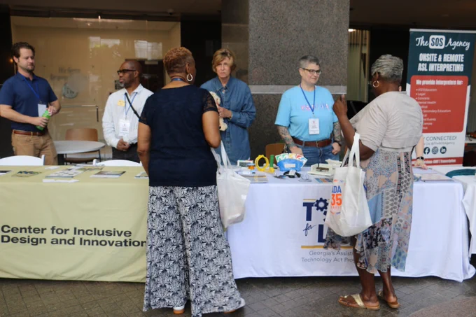 CIDI members at a booth, talking to patrons and potential customers.