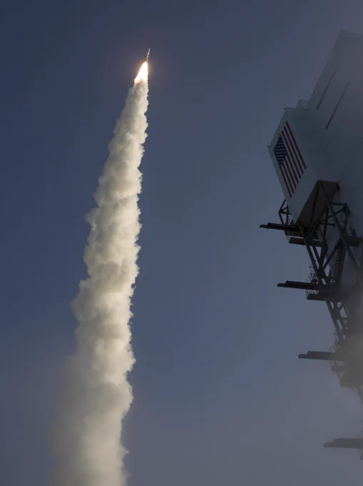 A United Launch Alliance Atlas V rocket with NASA’s Mars 2020 Perseverance rover onboard launches into a deep blue sky from Space Launch Complex 41, Thursday, July 30, 2020, at Cape Canaveral Air Force Station in Florida. The launch tower with an American flag painted on it is visible on the right side of the image. Photo Credit: NASA/Joel Kowsky