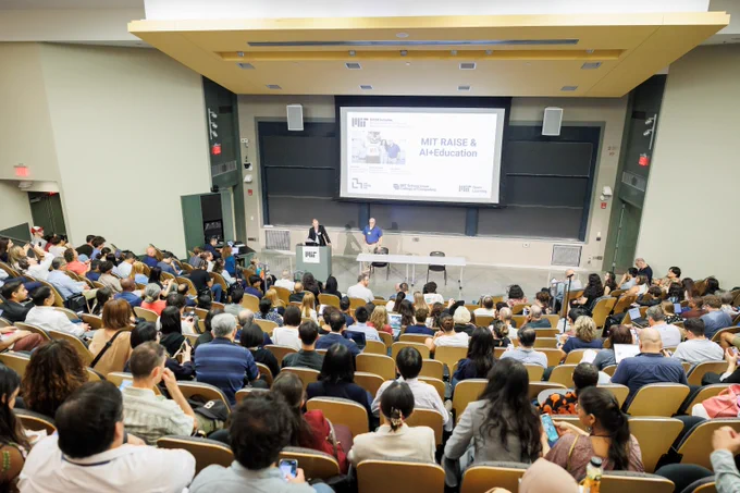 A crowded room seated in front of a slide displaying MIT AI & Education Summit.
