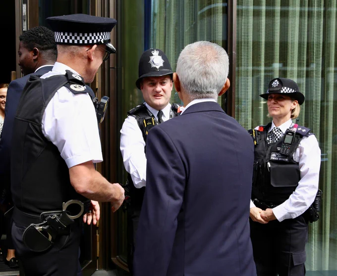 Mayor of London, Sadiq Khan shaking hands with a police officer.