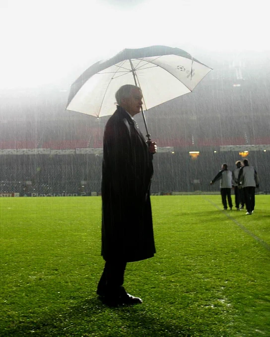 Sir Bobby Robson holding an umbrella