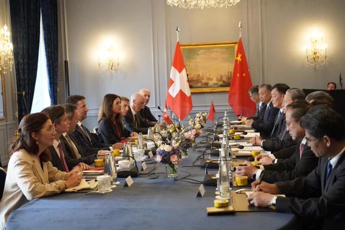 a group of people sitting at a table with flags