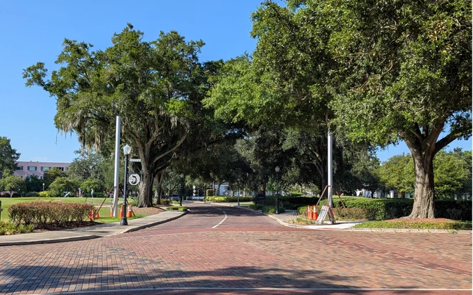 two silver poles on either side of a brick-lined street