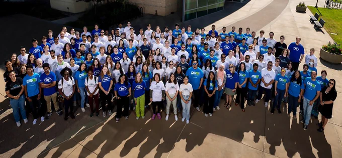 large group of students and mentors outside the supercomputing facility, all wearing Computing Scholars or Data Science Summer Institute t-shirts