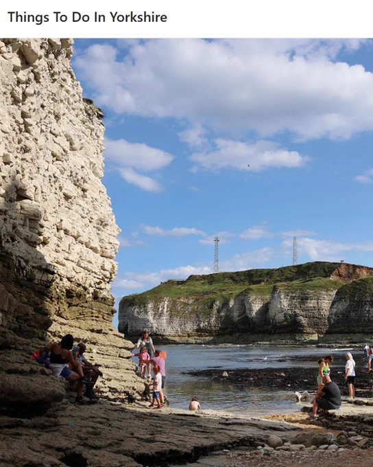 Visitors enjoying a sunny day by the rocky shores and cliffs of Flamborough Head in Yorkshire.