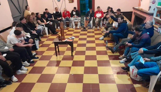 Rueda de adolescentes y adultos alrededor de pequeña mesa central con la Virgen , junto al Cardenal Sturla.