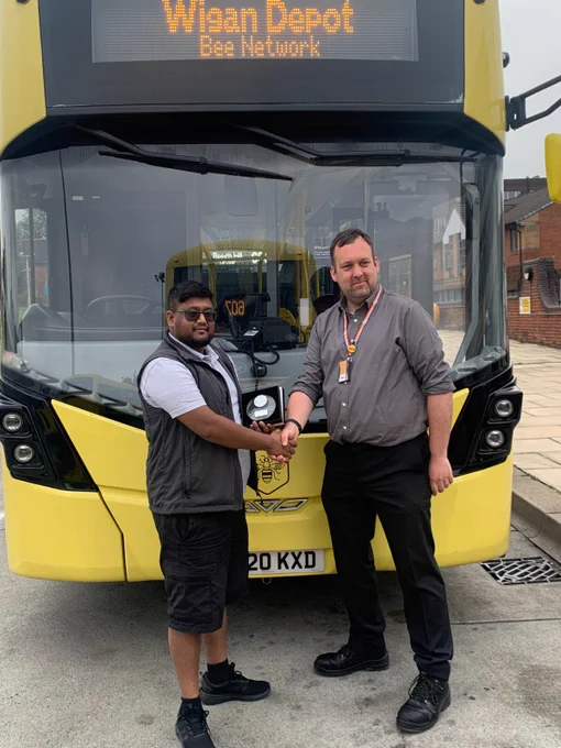 Go North West Bus Driver of the Year 2025 finalist, Fahim, being presented with a commemorative trophy by a manager.