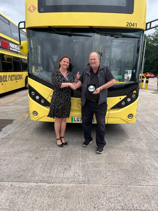 Go North West Bus Driver of the Year 2025 finalist, Stephen, being presented with a commemorative trophy by a manager.