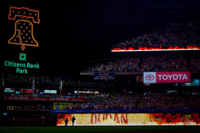 Johan Duran enters the ballpark as flames are displayed on the video boards. Fans are lighting up the dark stadium with their phone flashlights.